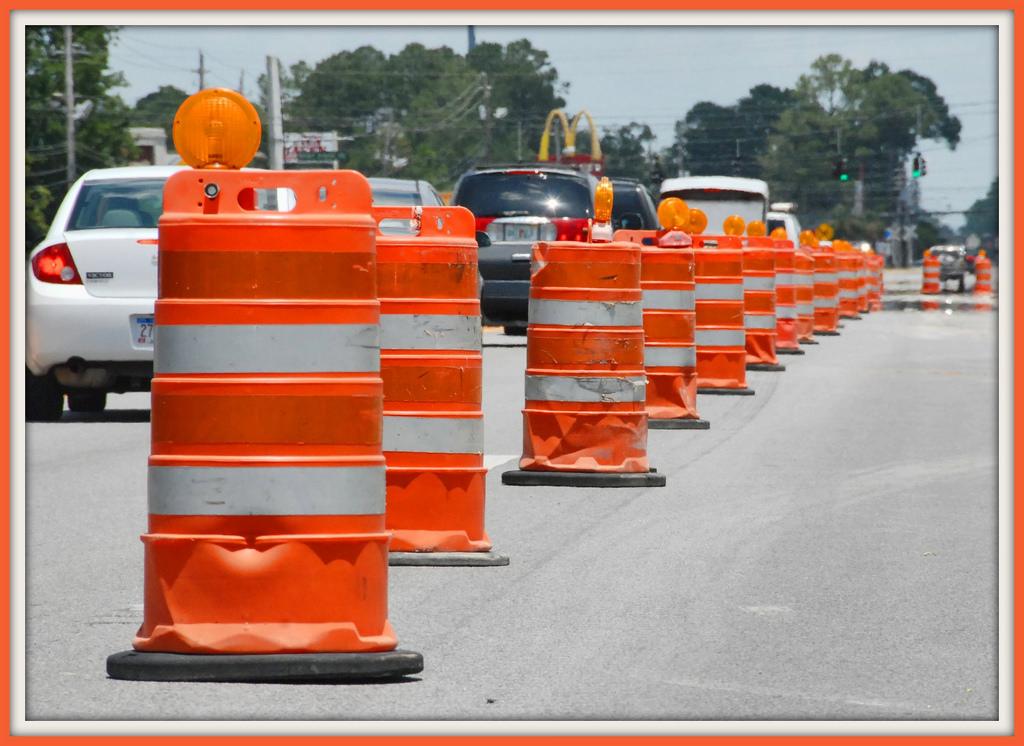 Road construction barrels lining street