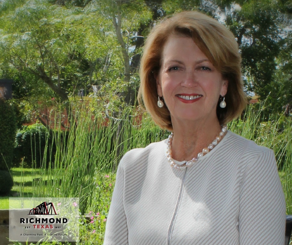 Mayor Moore in beige suit with logo image